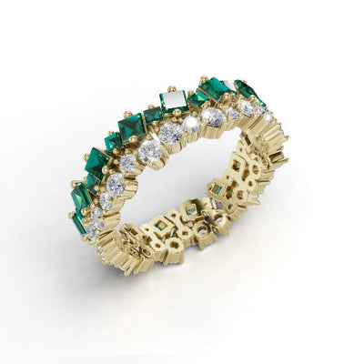 Gold ring with emeralds and diamonds on a white background